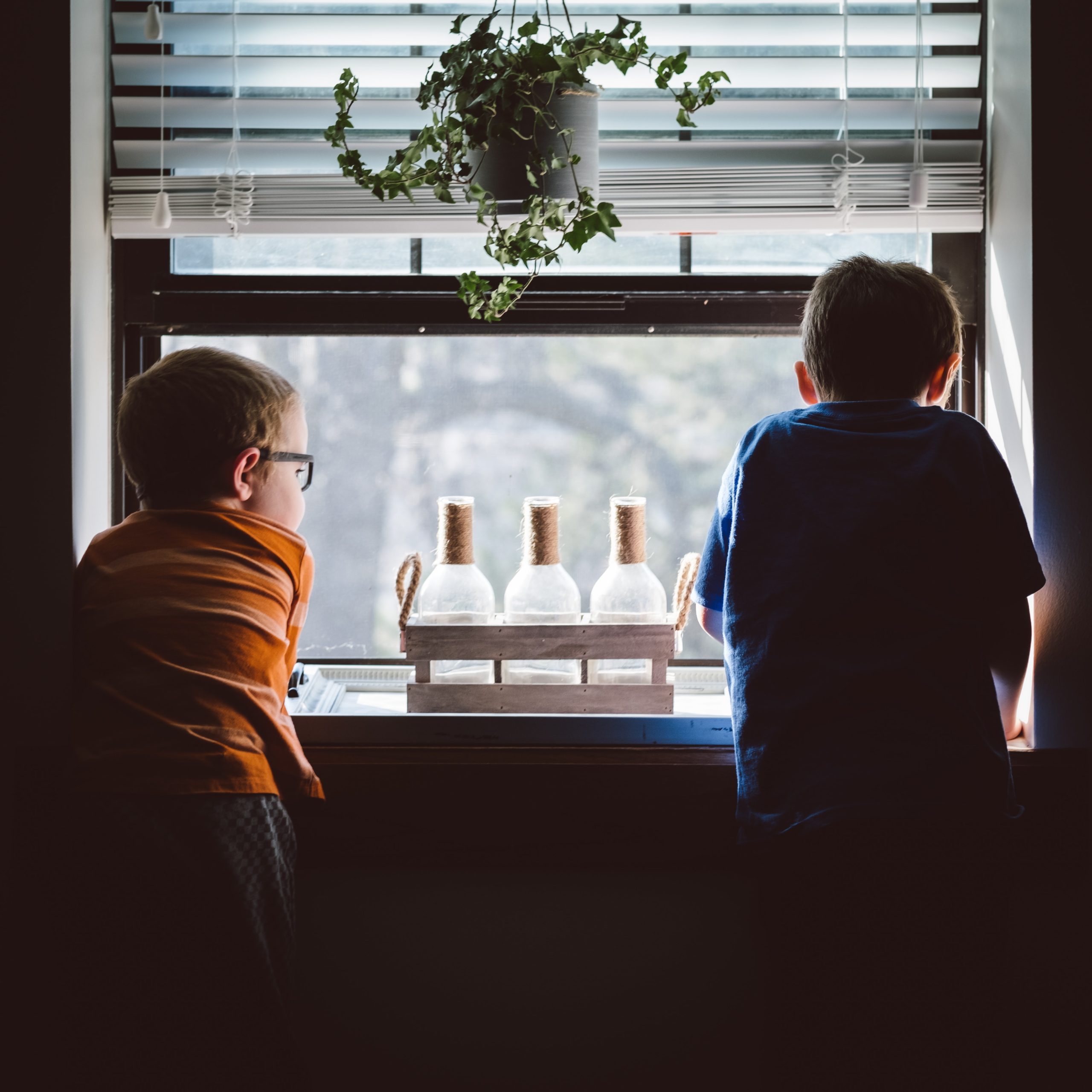 Two boys look out a window (Photo by Andrew Seaman on Unsplash)