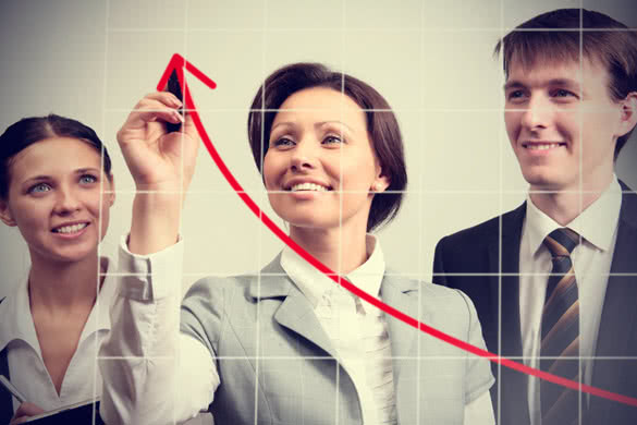 Business woman drawing a graph on a glass window in an office